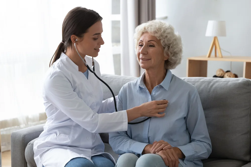 A physiotherapist performing chest physiotherapy for COPD on an elderly woman to improve breathing and enhance lung function