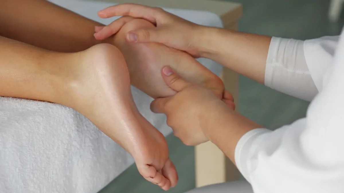 A clinician examines an adult’s foot during a foot assessment.
